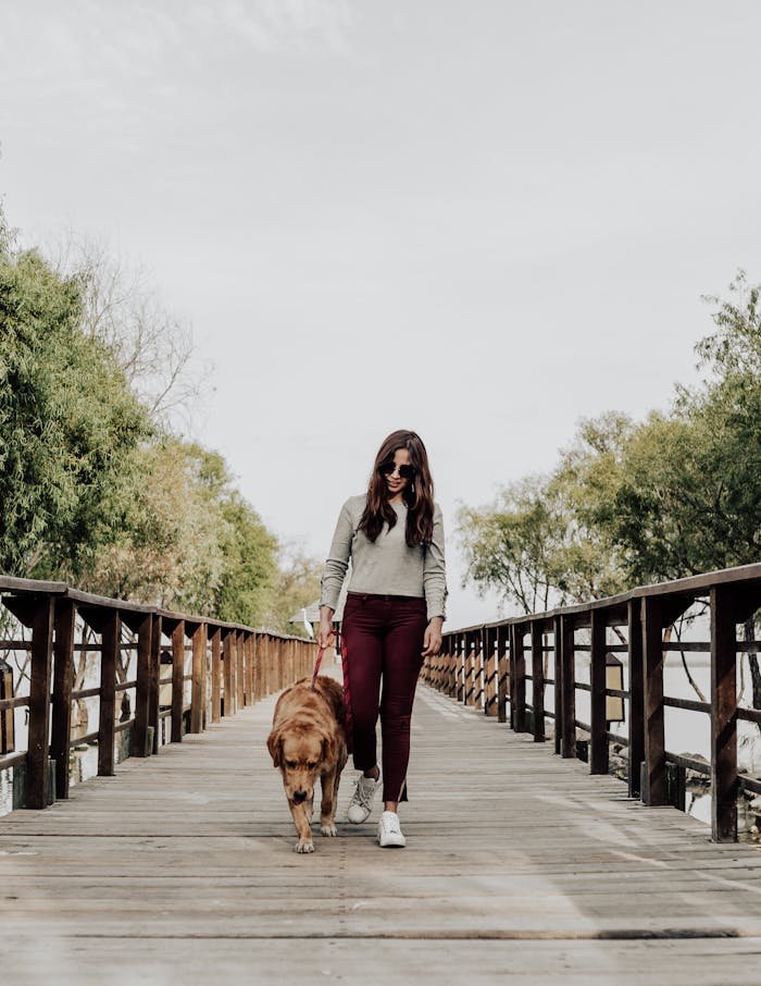 who-we-are Woman with sunglasses walking dog on a wooden bridge in Jocotepec, Mexico.